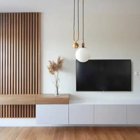 Media wall with a wall-hung white console stepping up into an oak ledge, a walnut slat panel over its left end