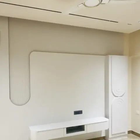 Minimalist living room TV wall with a floating white console under a curved fluted arch panel, beside a tall wave-textured storage unit.