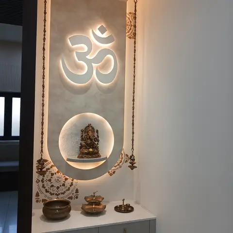 Modern pooja niche with a backlit Om symbol above a circular backlit shelf for a Ganesha idol, and a floating drawer console below.