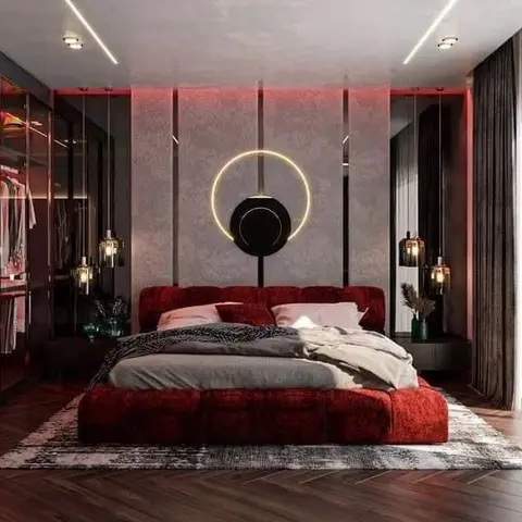 Moody bedroom with a deep red channel-tufted platform bed under a glowing ring pendant light