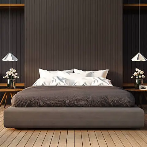 Moody bedroom with a grey upholstered platform bed centred against a charcoal fluted wood-panel wall