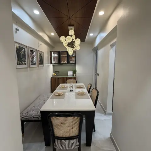 Narrow dining room with a white stone-top table and cane-back black bentwood chairs, a geometric-print bench down one side