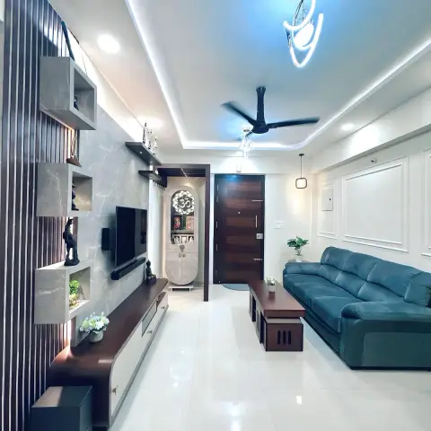 Narrow living room with a grey stone-look TV wall carrying backlit floating display boxes, a dark fluted panel at the near end, a teal leather sofa opposite