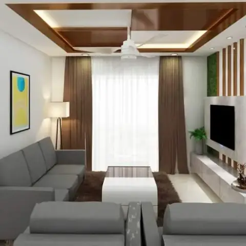 Narrow living room with a grey L-sofa facing a marble-and-slat TV wall, under a false ceiling banded with dark wood strips and lit from a peripheral cove.