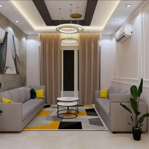 Narrow living room with twin grey sofas facing a mustard-and-black geometric rug under a two-tier ring pendant chandelier