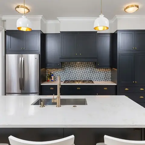 Navy shaker-style kitchen island with brass pendant lights and a patterned cement-tile backsplash.