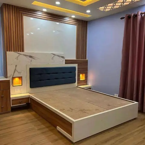 Newly built platform bed with a blue channel-tufted headboard on a white marble panel