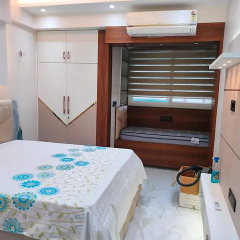 Newly finished bedroom with a white and walnut wardrobe with mirror-edge V-detailing, and a built-in window-seat daybed nook