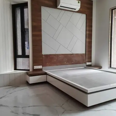 Newly finished bedroom with a white laminate platform bed still without its mattress