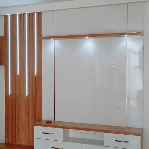 Newly finished living room TV wall with backlit vertical wood strip panelling and a glossy mirrored backdrop above a white-and-wood console