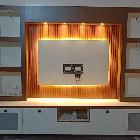 Newly installed living room TV unit with a backlit fluted wood panel behind the screen mount