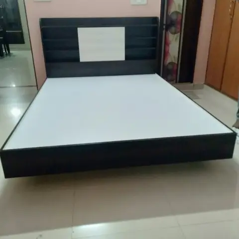 Newly installed wenge-and-white laminate platform bed with an integrated shelf headboard