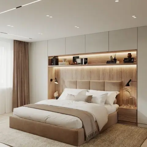 Oak headboard wall with a strip-lit display ledge of books and vases under white overhead lockers