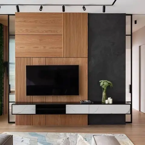 Oak media wall that mixes flat veneer, fine vertical fluting and a charcoal stone slab