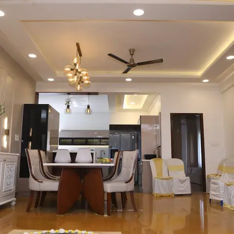 Open dining area with a six-seater wood dining table and cluster pendant light beneath a cove-lit tray ceiling