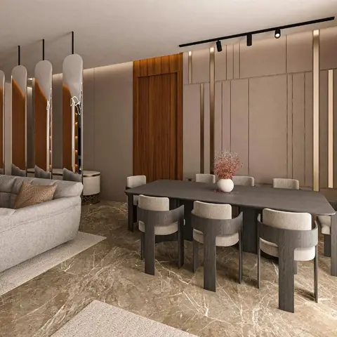 Open dining area with sculptural curved-wood dining chairs around a dark stone-top table, a bronze-trimmed panelled wall, and polished beige marble flooring.