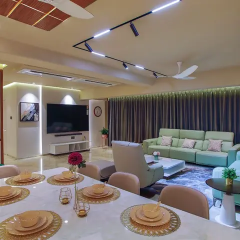 Open dining-living space with a marble-top dining table set with gold chargers in the foreground