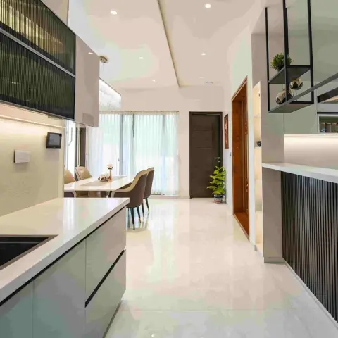 Open galley kitchen in sage green with reeded-glass black-framed wall cabinets, LED-lit quartz counters and a black fluted breakfast-counter front