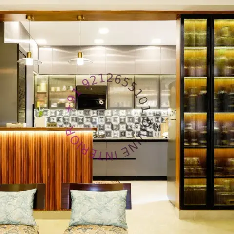 Open kitchen seen across a fluted-teak breakfast counter with LED under-lip, black-and-white geometric dado behind the hob run and a floor-to-ceiling amber