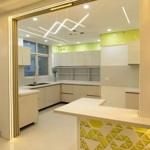 Open kitchen with a lime-green accent wall, glossy cream cabinetry, a zigzag linear LED light fixture