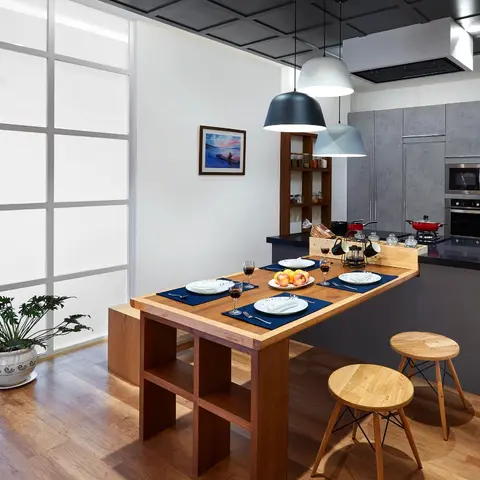 Open kitchen with grey concrete-textured handleless cabinets and integrated wall oven and microwave