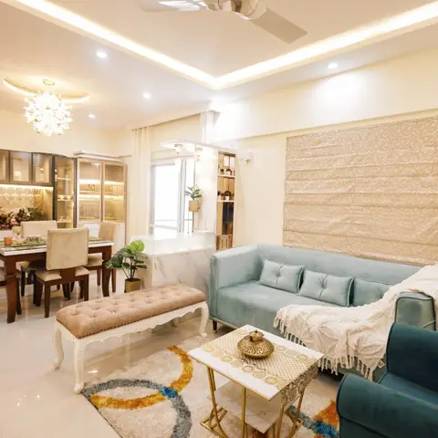 Open living-dining space with a teal velvet tufted sofa and matching tufted bench facing a marble-and-brass coffee table