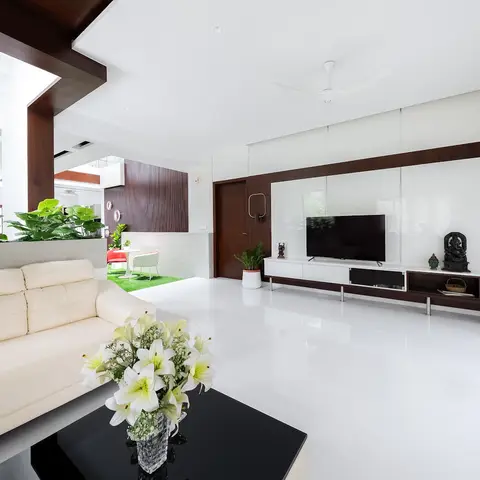 Open living room with a glossy white floor, cream leather sofa facing a dark wood-veneer TV feature wall