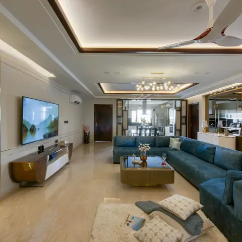 Open living room with a teal velvet channel-tufted sectional sofa, a brass-trimmed coffee table and walnut floating TV console