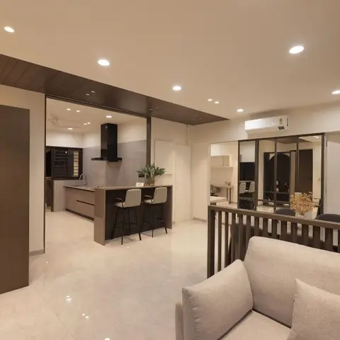 Open-plan apartment showing a breakfast counter kitchen with a wood-clad ceiling drop, a living area sofa