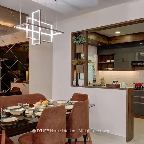 Open-plan dining and kitchen with a rust-velvet dining set under a geometric LED pendant, a mirrored diamond-pattern wall