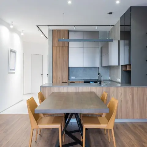 Open-plan dining and kitchen with a mustard-leather-chair dining set under a linear pendant light