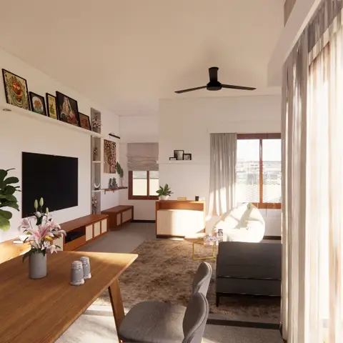 Open-plan dining and living area seen together, with a wooden dining table in the foreground and a gallery wall of framed art above a TV console beyond.