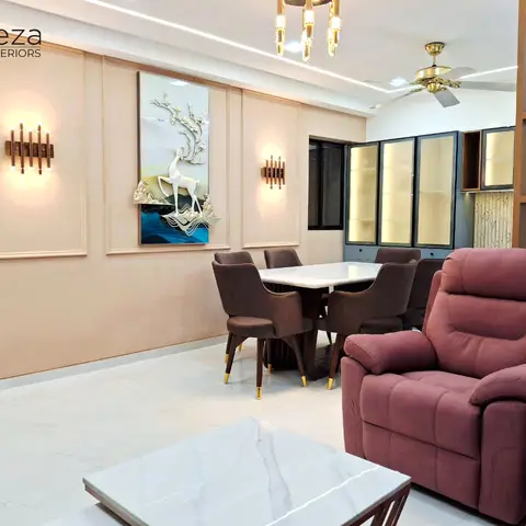 Open-plan dining and living area with a peach panel-moulding wall featuring a 3D deer wall art piece, a marble-top dining table