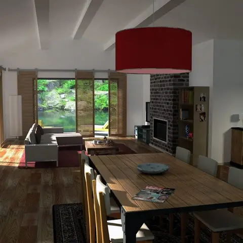 Open-plan dining and living space with a wood dining table under a red drum pendant, an exposed brick fireplace