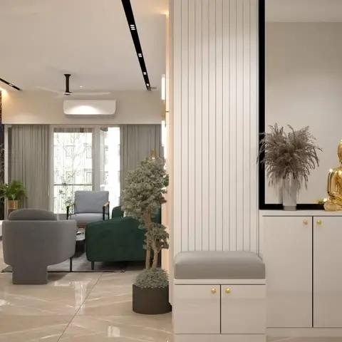 Open-plan entrance foyer with a gold Buddha statue on a white console, leading into a living area with a black-marble clad TV wall, grey and green armchairs