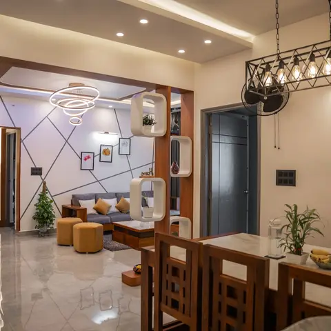 Open-plan entrance, living and dining area: a wooden tree wall-art foyer, grey sofa with mustard ottomans under a ring chandelier