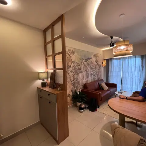 Open-plan entrance-living-dining space with a wood-and-glass jaali screen beside a shoe cabinet