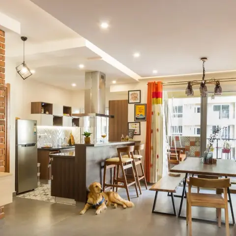 Open-plan flat photographed with a golden retriever lying on the grey floor - exposed brick TV wall on the left