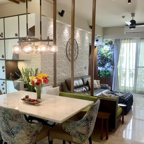Open-plan frame across a marble dining table with palm-print chairs under a five-globe linear pendant
