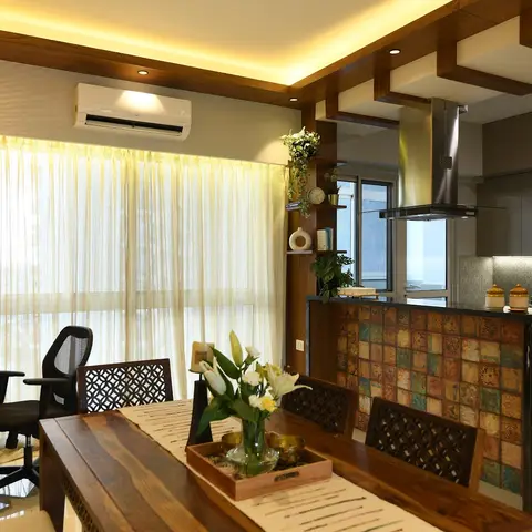 Open-plan frame showing a carved sheesham dining table, a home-office desk with mesh chair