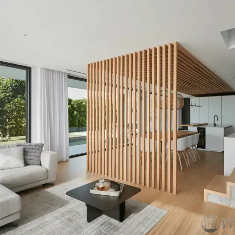 Open-plan ground floor split by a floor-to-ceiling oak batten screen that folds over into a slatted ceiling raft above the dining bar