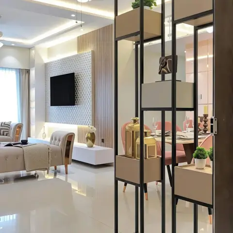 Open-plan living and dining separated by a black metal box-shelf partition, with a fluted TV feature wall on one side and pink dining chairs glimpsed through it