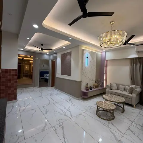 Open-plan living area with glossy marble flooring, a multi-level cove-lit ceiling with two fans and a crystal drum chandelier