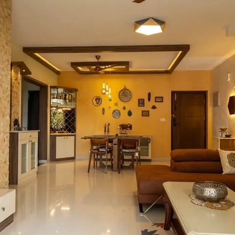Open-plan living-dining space with a mustard textured accent wall styled with a curated wall-art and clock arrangement