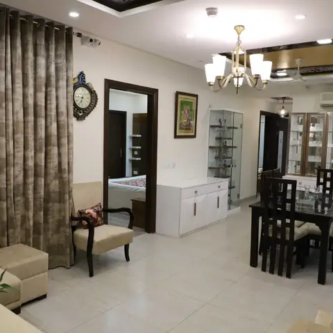 Open-plan living-dining space with a dark wood dining set beneath a multi-arm chandelier, a mirrored glass crockery display unit