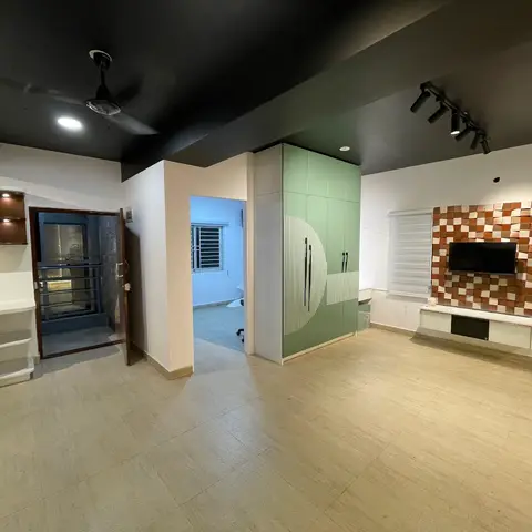 Open-plan living-kitchen with a green fluted wardrobe pillar at the entry, a 3D geometric terracotta tile TV feature wall