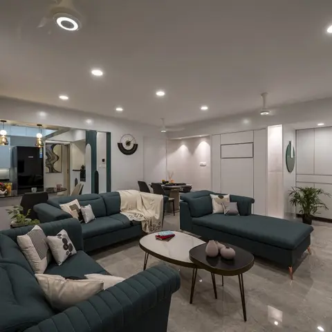 Open-plan living room with a teal channel-tufted velvet sofa set and layered marble-top nesting coffee tables
