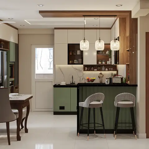 Open-plan space showing a sage-green modular kitchen with a marble backsplash and bar seating, a wood dining table