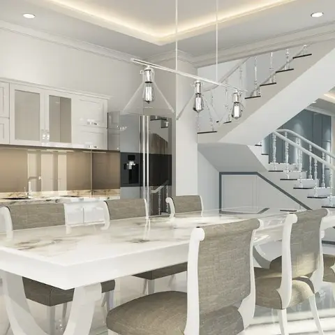 Open-plan space with a marble-top dining table under cone pendant lights, a glossy white kitchen along one wall