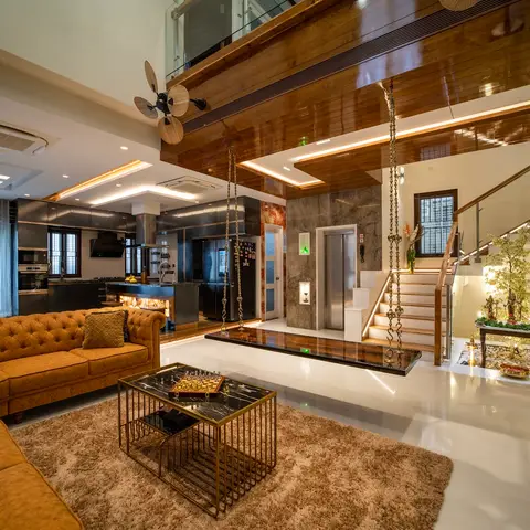 Open-plan villa interior spanning a tan leather sectional living area, a black modular kitchen